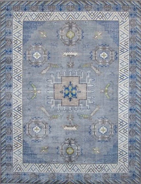 A blue and white patterned rug with geometric designs and symmetrical motifs.