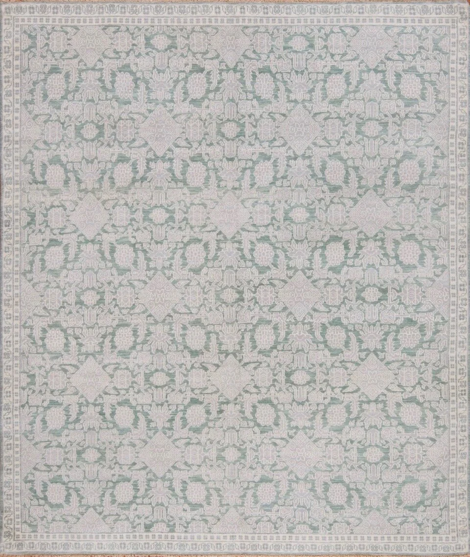 A light-colored, intricate patterned area rug with floral and geometric designs in soft pastel colors.