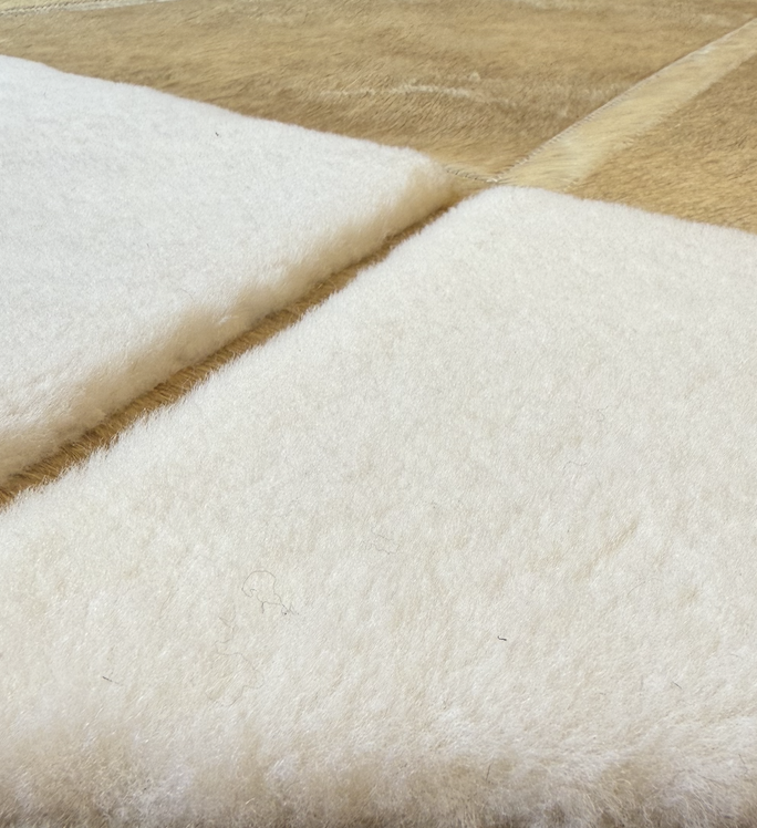Close-up of beige and white overlapping felt or fabric pieces on a wooden surface.