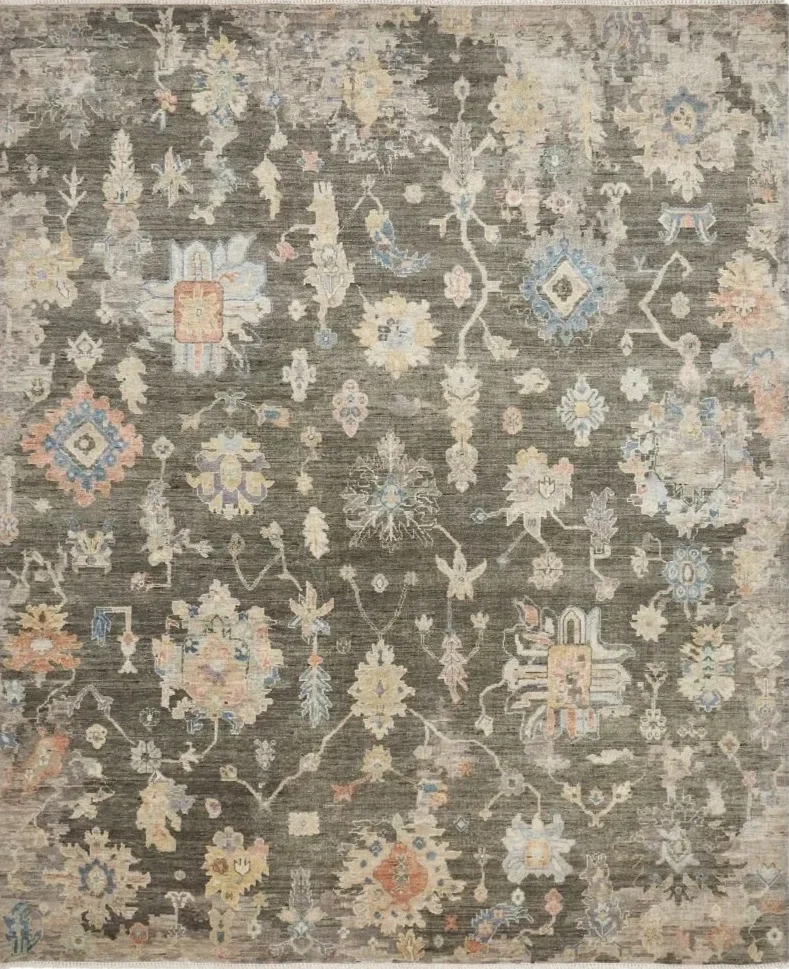 A traditional rug with intricate floral and geometric patterns in muted beige, gray, and soft pastel colors.