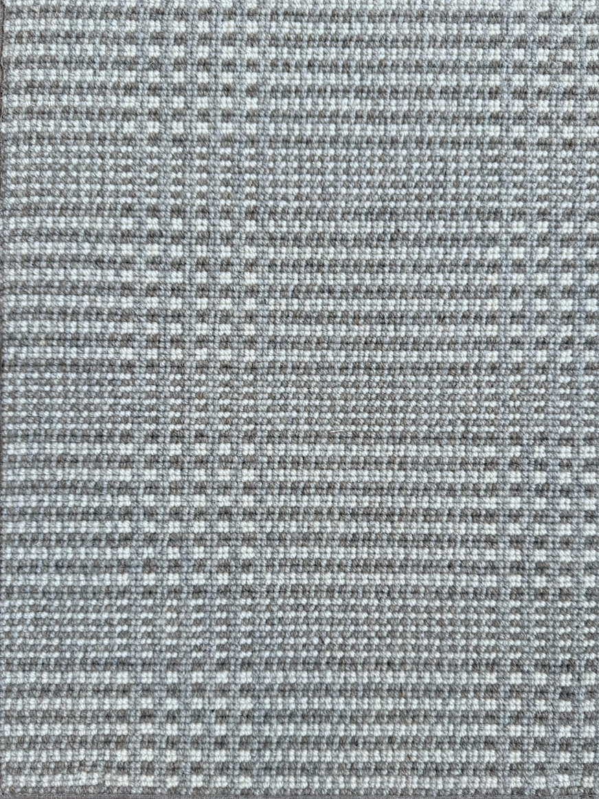 Close-up of a textured fabric with a weave pattern in shades of gray and beige.