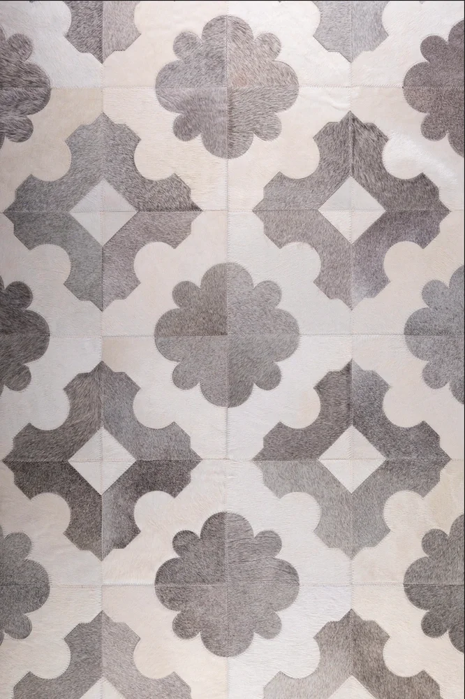 Patterned floor tiles with geometric and floral shapes in shades of gray and white.