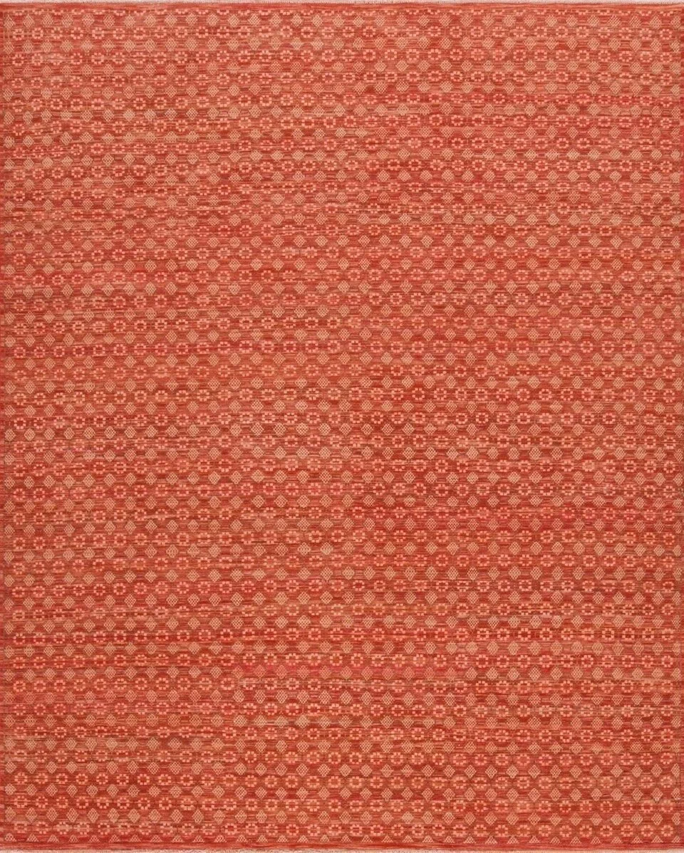 Close-up of a red fabric with intricate, repeating geometric patterns in beige.