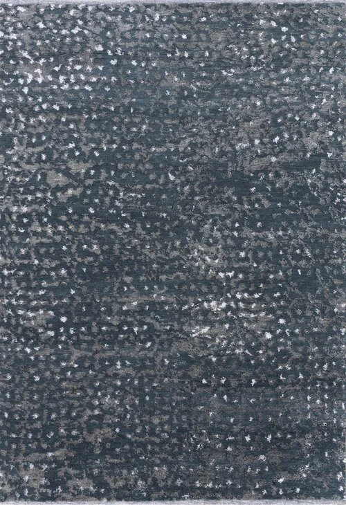 Close-up of a dark textured surface with scattered small white specks, possibly a weathered or worn material.