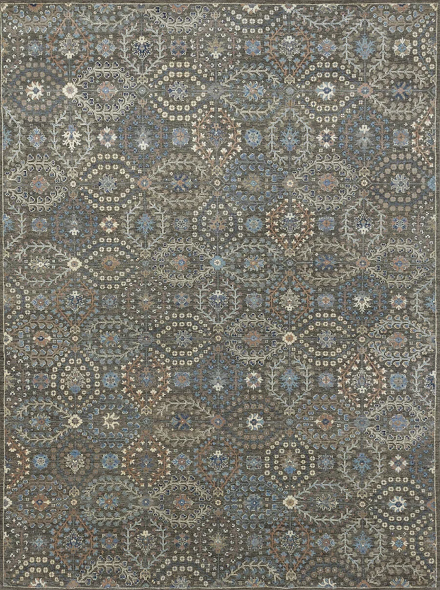 An intricate area rug with a detailed geometric and floral pattern in shades of blue, beige, and brown.