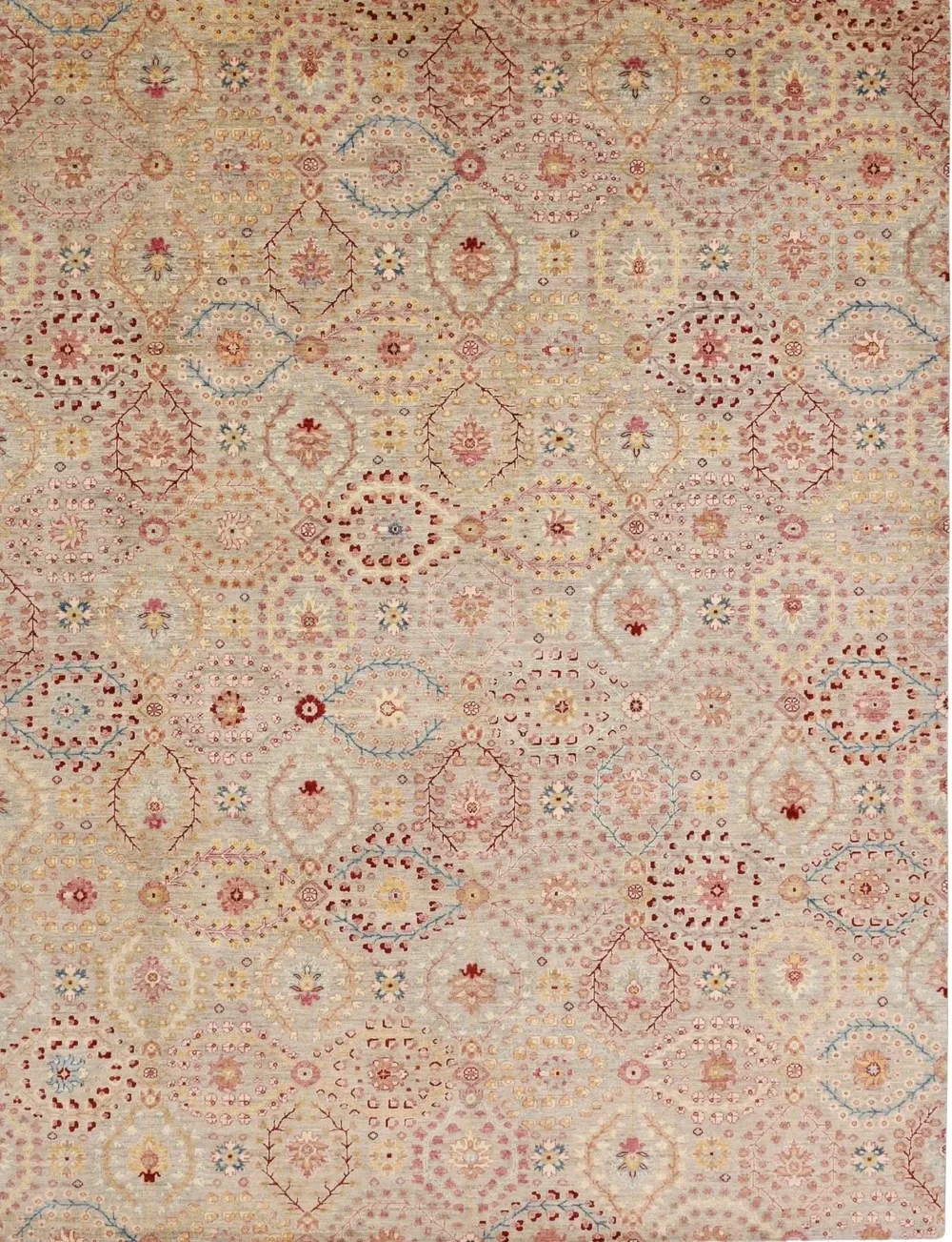 A detailed area rug with a floral and geometric pattern in shades of pink, cream, red, yellow, and blue.