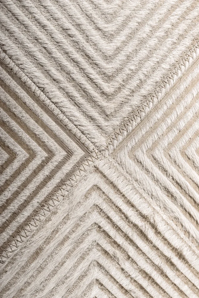 Close-up view of a beige and cream patterned area rug with zigzag and geometric designs.
