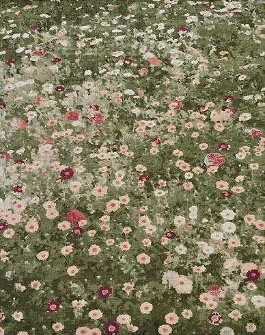 A field of various pink, red, and white flowers blooming on green grass.