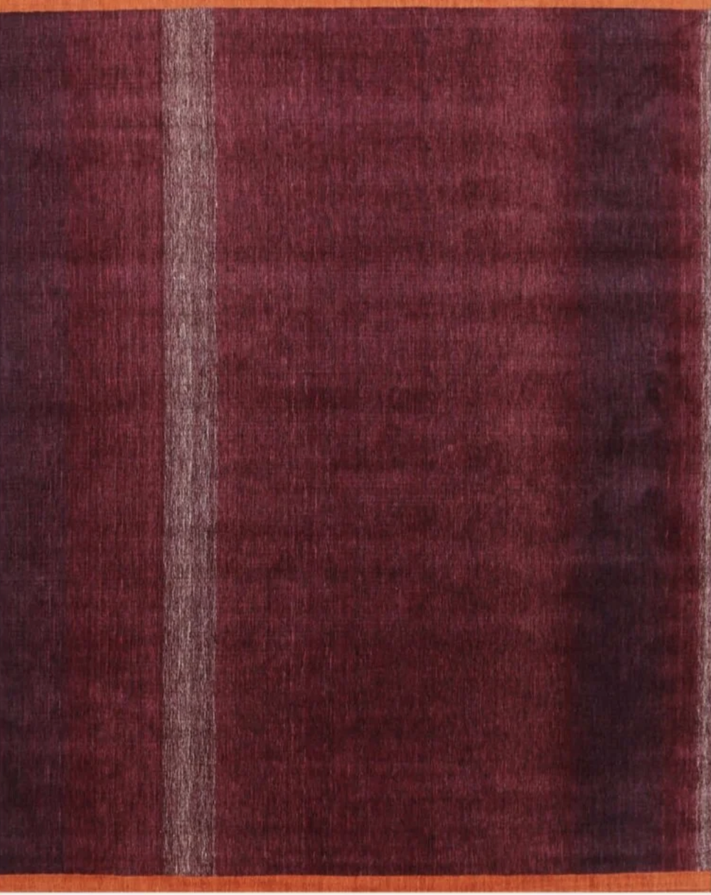 Close-up of a red textured fabric or carpet with a light vertical stripe near the left edge.