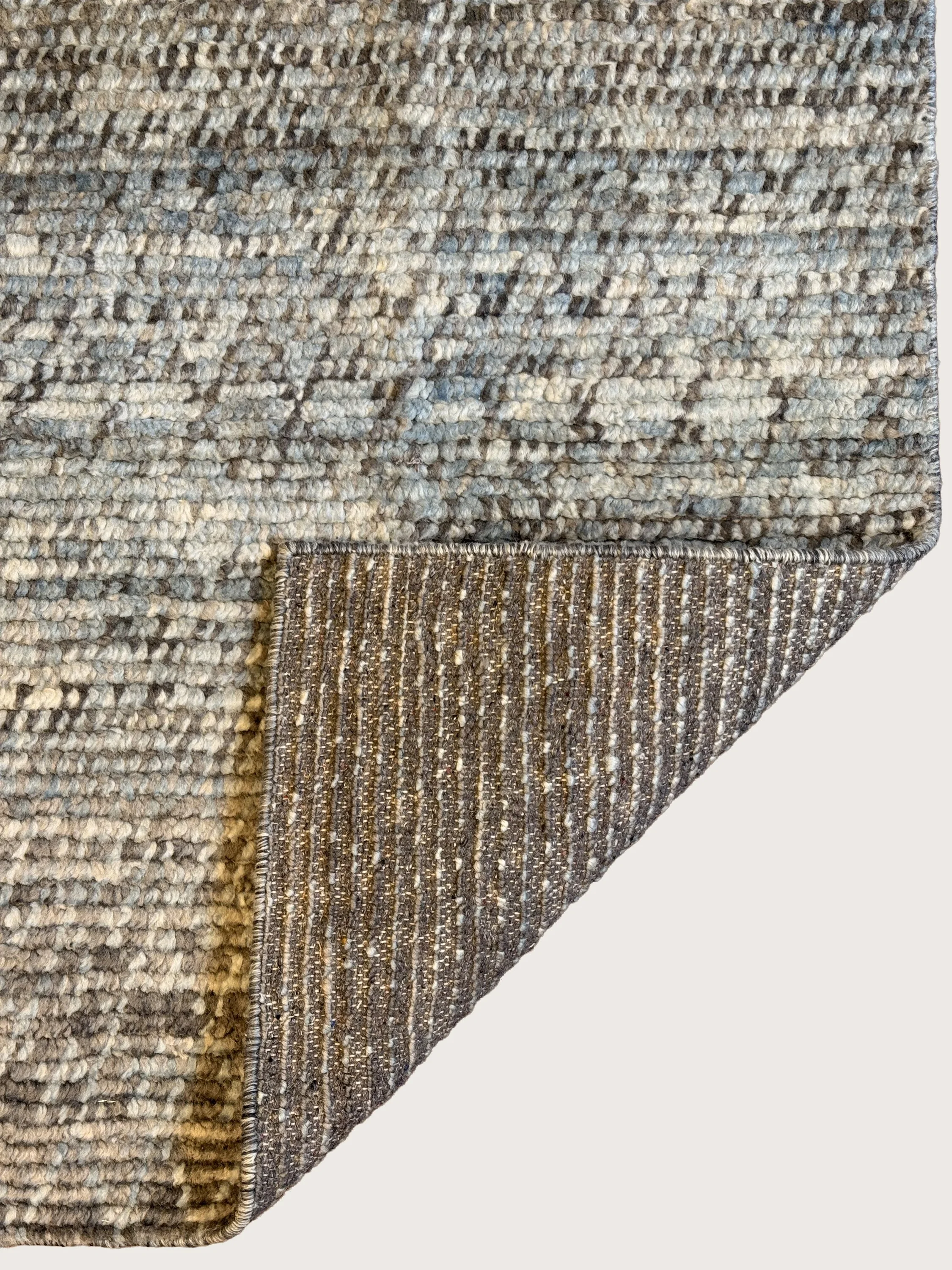 Close-up of a textured, patterned gray and beige area rug.