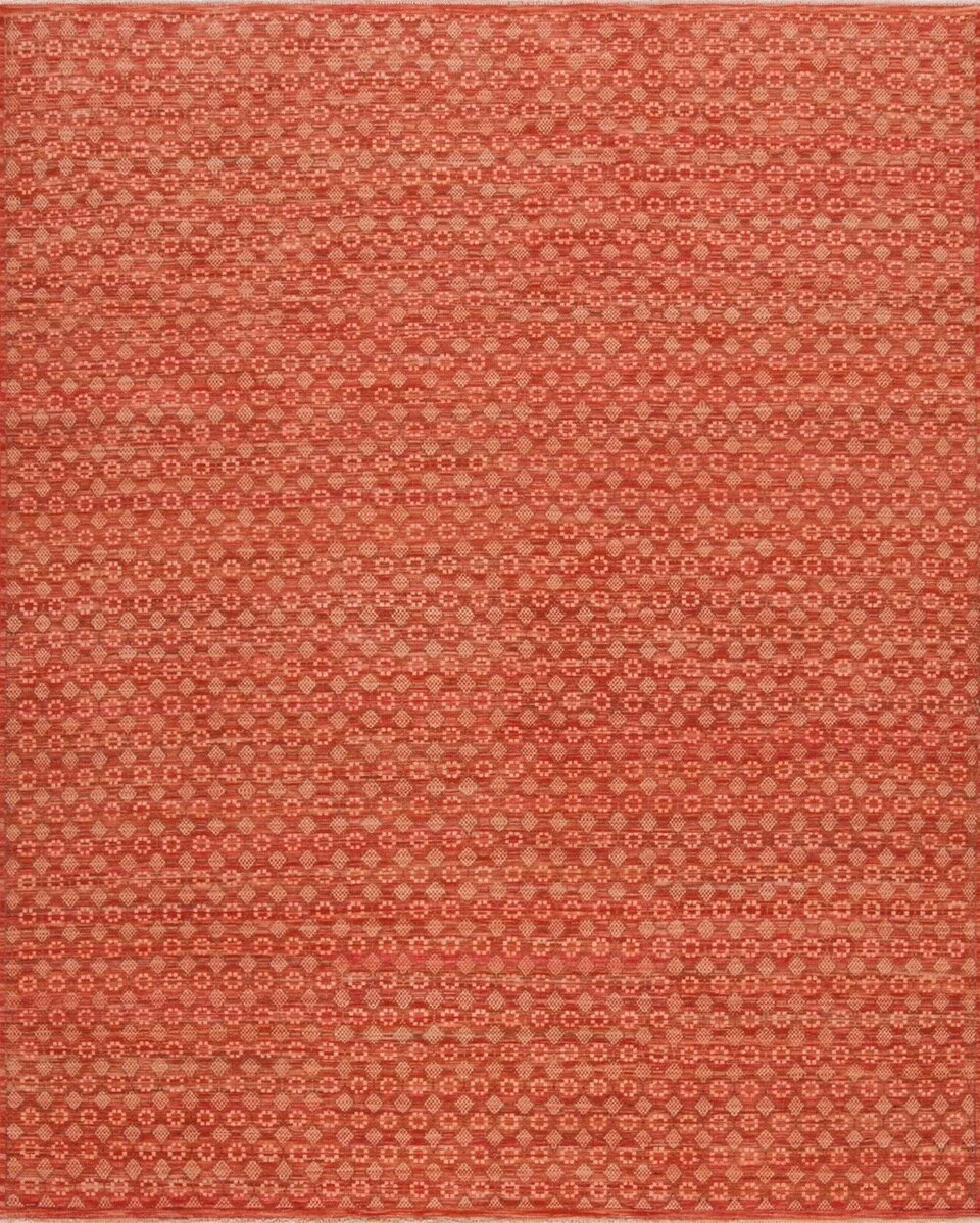 Close-up of a woven textile with a geometric red and beige pattern.