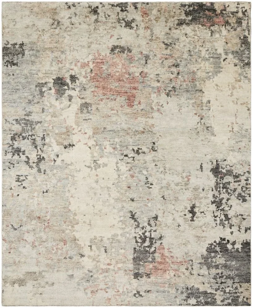 A light-colored area rug with an abstract, distressed pattern in shades of beige, gray, black, and subtle hints of pink.