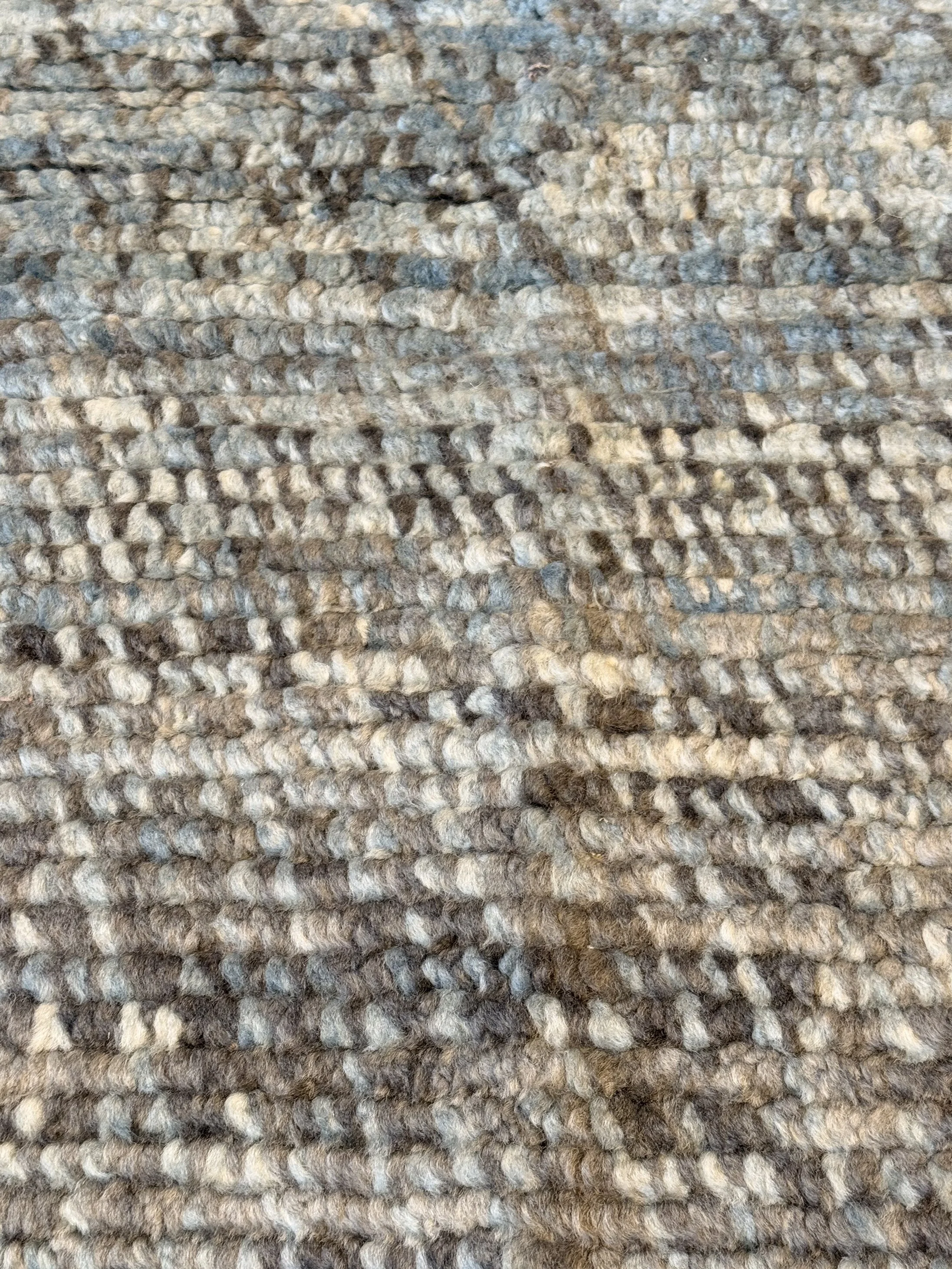 Close-up of a textured, patterned gray and beige area rug.