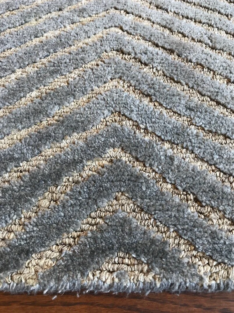 Close-up of a textured gray and beige geometric-patterned rug.
