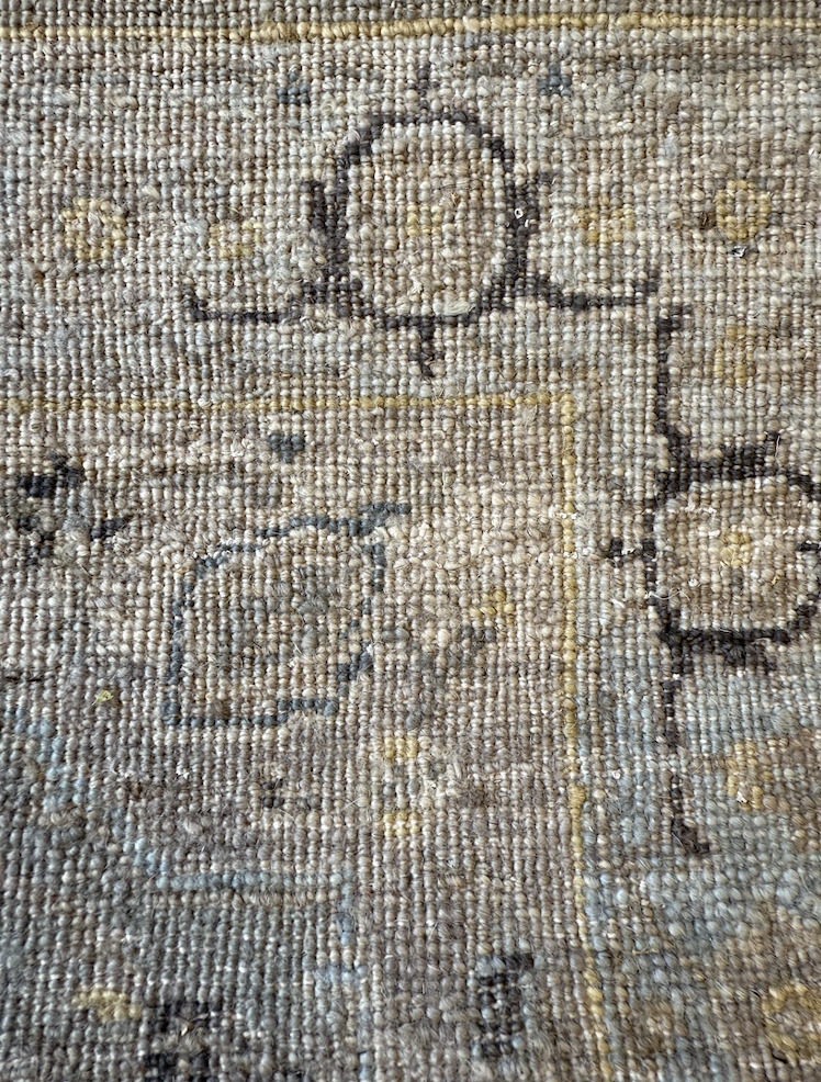 Close-up of a woven carpet with a floral pattern and the word 'Love' written in dark lines.