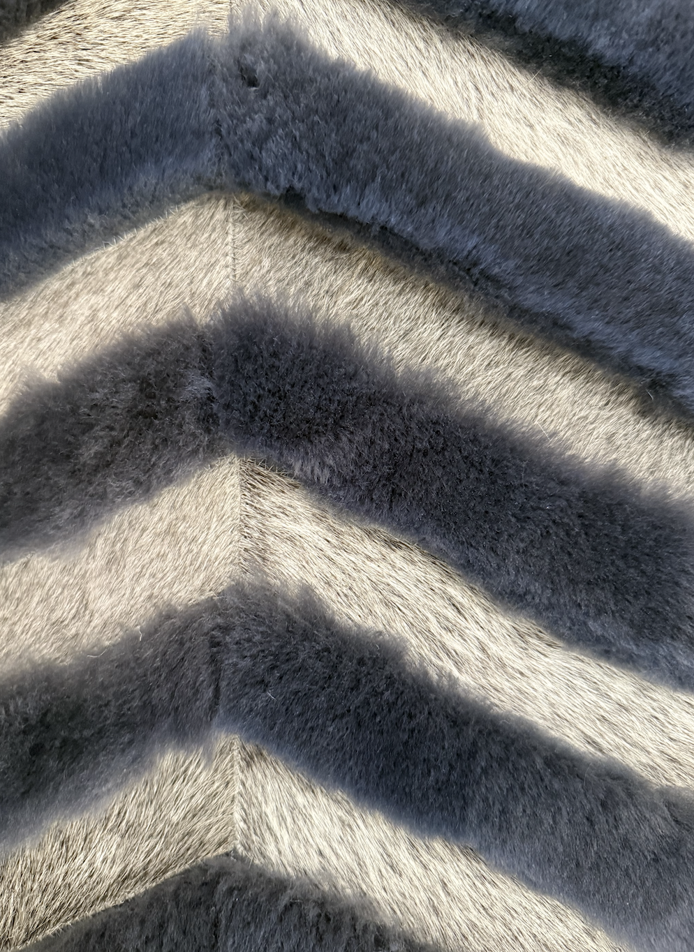 Close-up of animal fur with a stripe pattern alternating between dark and light colors.