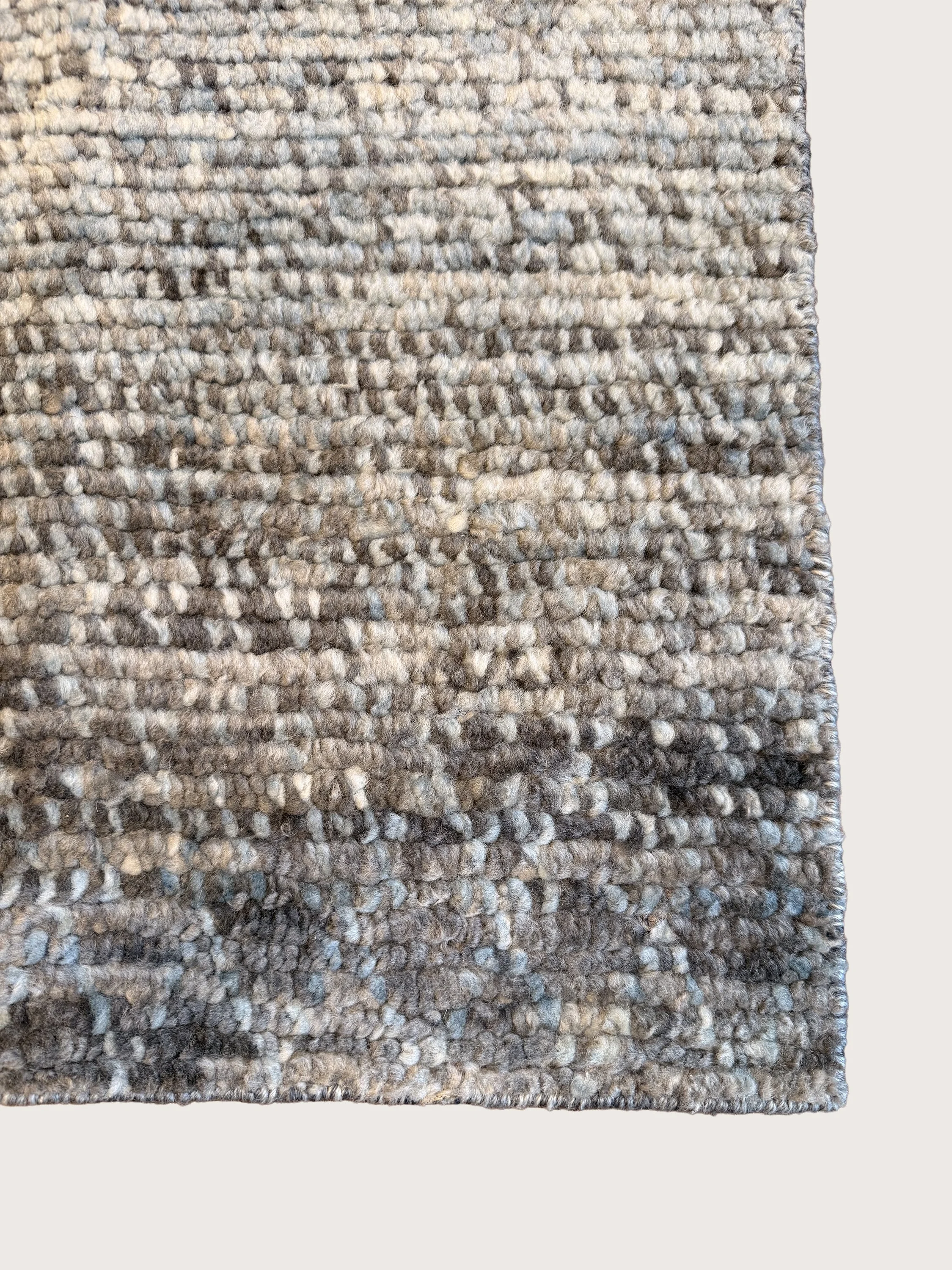 Close-up of a textured, patterned gray and beige area rug.