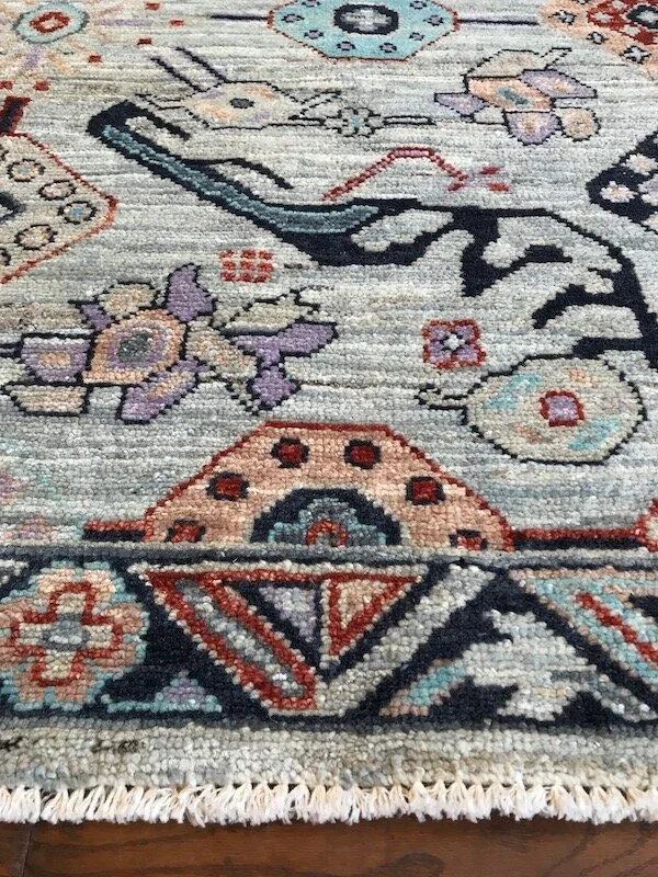Close-up of a colorful, patterned rug with floral and geometric designs.