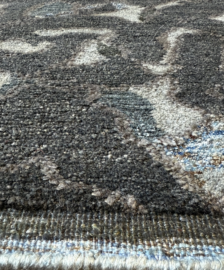 Close-up of a textured, multicolored carpet with visible fibers and pattern.