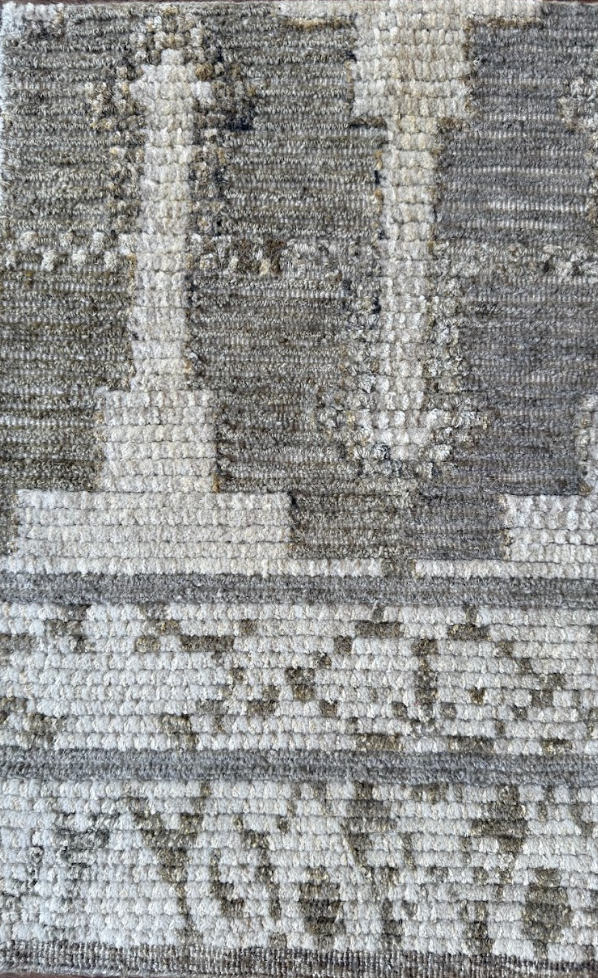 Close-up of a textured beige and gray area rug with a geometric pattern and the word "LOVE" woven into it.