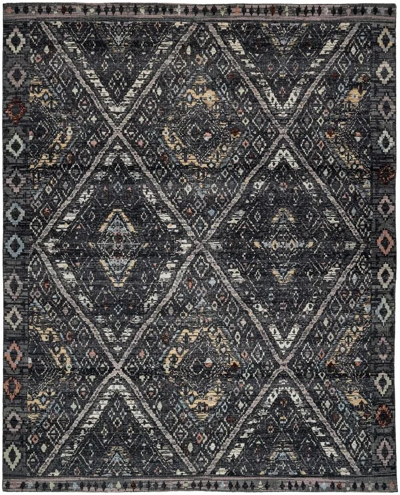 A traditional ethnic rug with intricate geometric patterns in dark colors, mostly black, beige, and hints of other earthy tones.