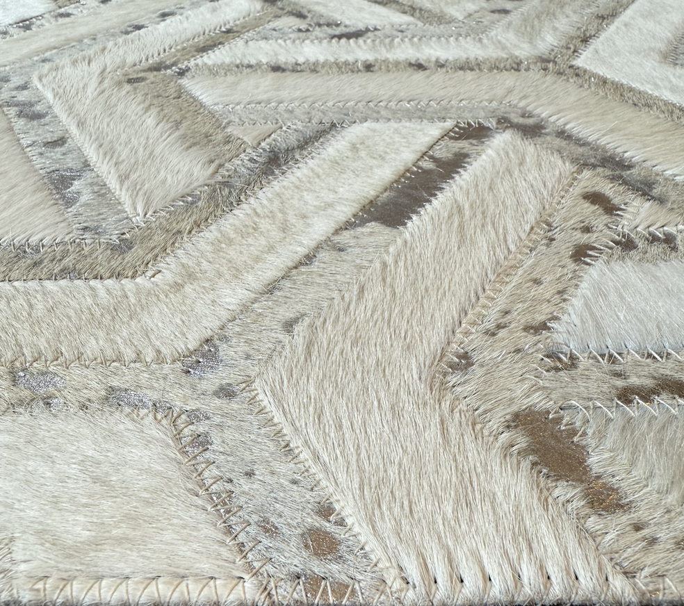 Close-up of a textured area with cream-colored furry patches stitched onto a surface.