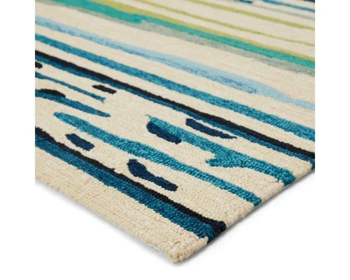 Close-up of a beige area rug with blue and black abstract stripes.