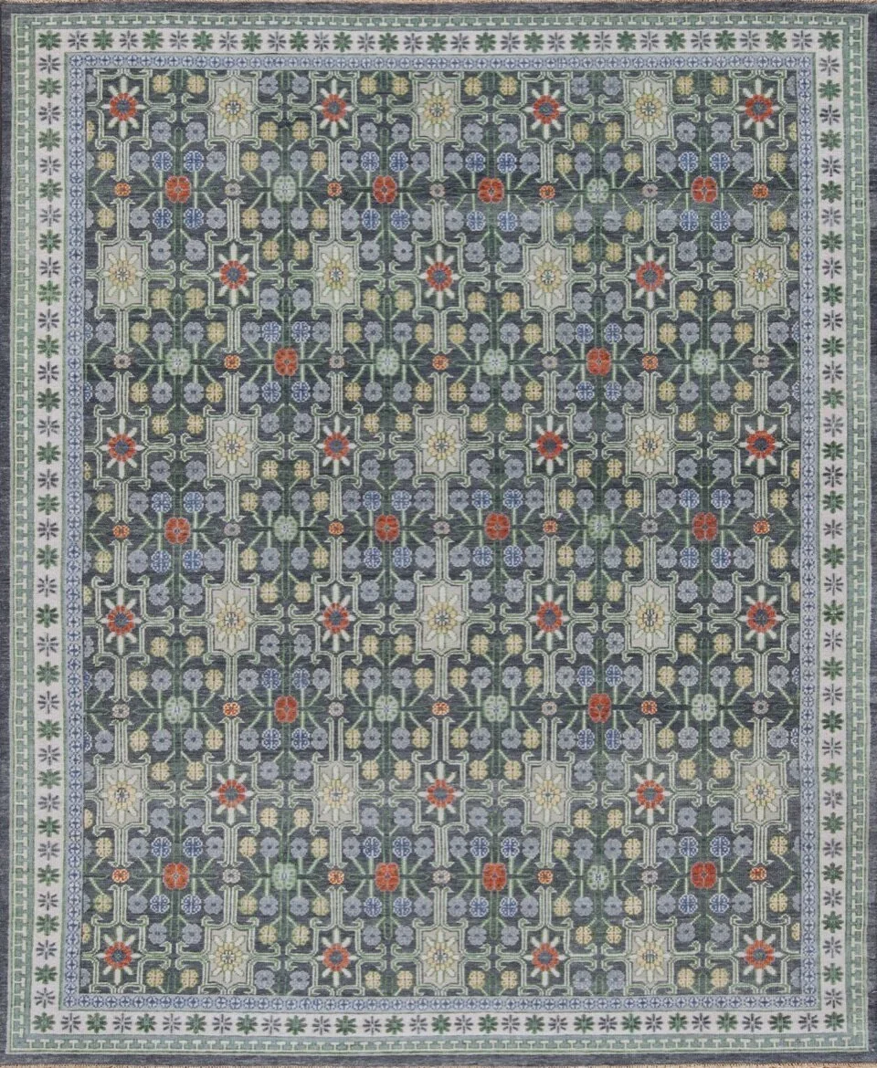 A detailed floral patterned rug with a dark background, decorated with various flowers in red, yellow, purple, and green, bordered with a white and green floral motif.