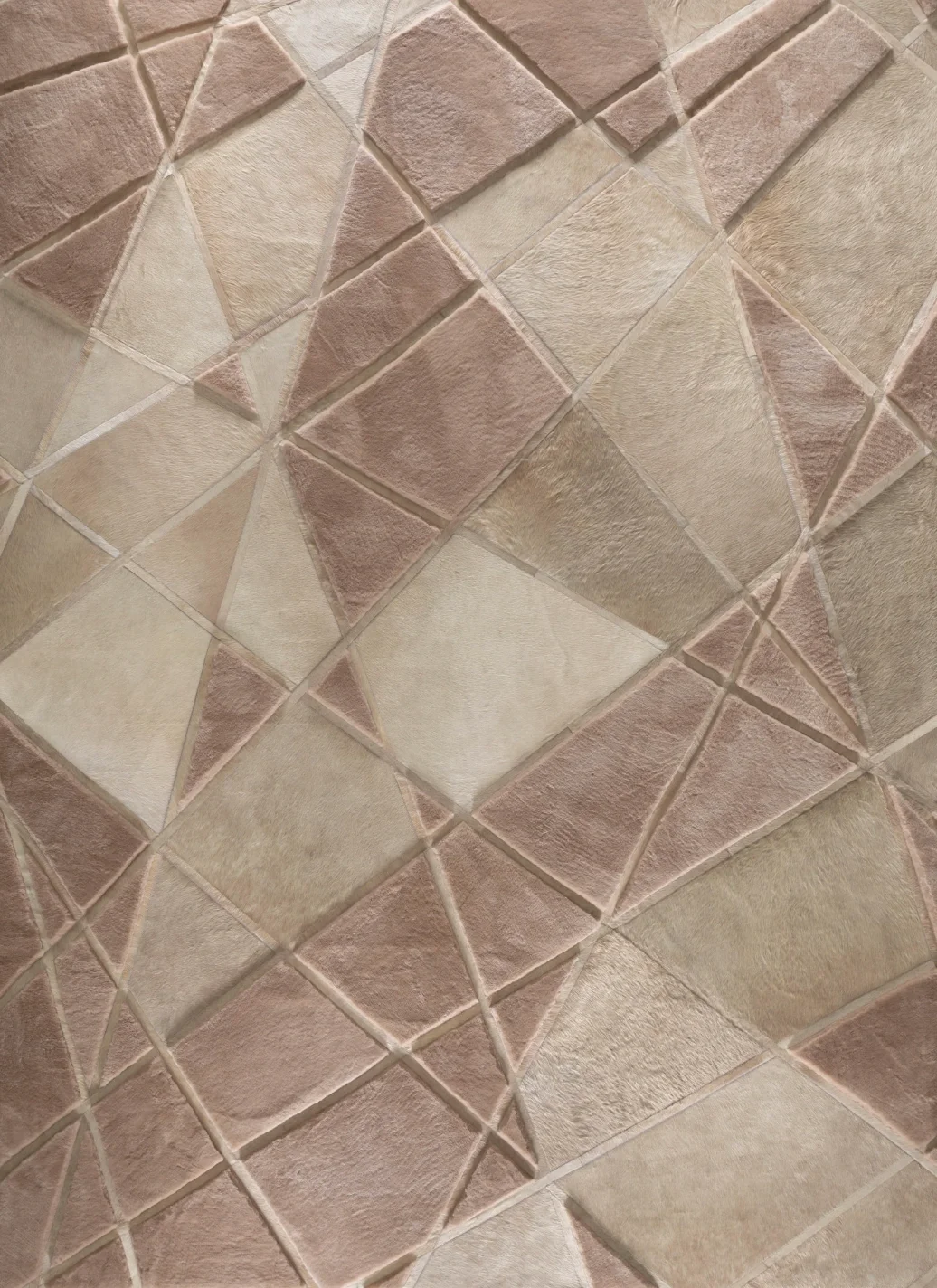 Close-up of a tiled surface with a geometric pattern in shades of light pink and beige, featuring various shapes such as triangles and trapezoids.