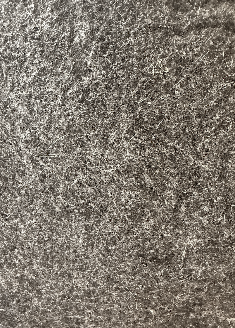 Close-up of a textured, fuzzy, dark brown fabric surface.
