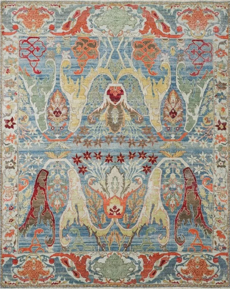 A detailed, colorful traditional Persian-style rug with symmetrical floral, scroll, and geometric patterns in shades of red, blue, green, yellow, and beige.