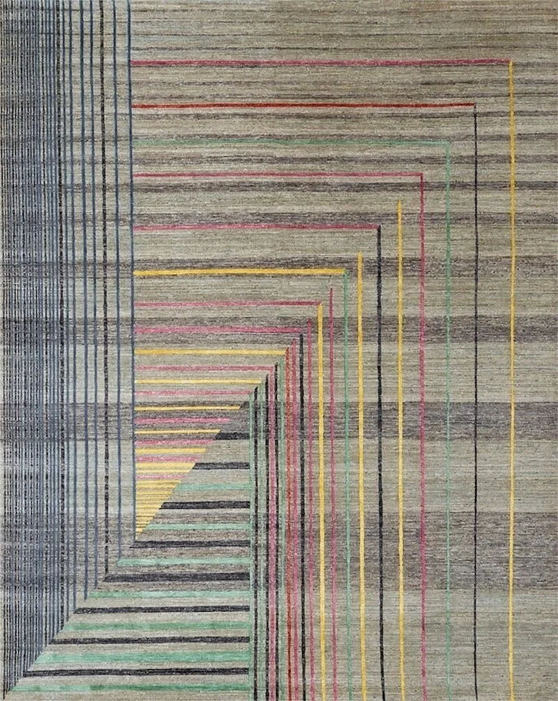 Colorful geometric rug with lines in red, yellow, green, black, and blue forming a staircase pattern on a gray background.