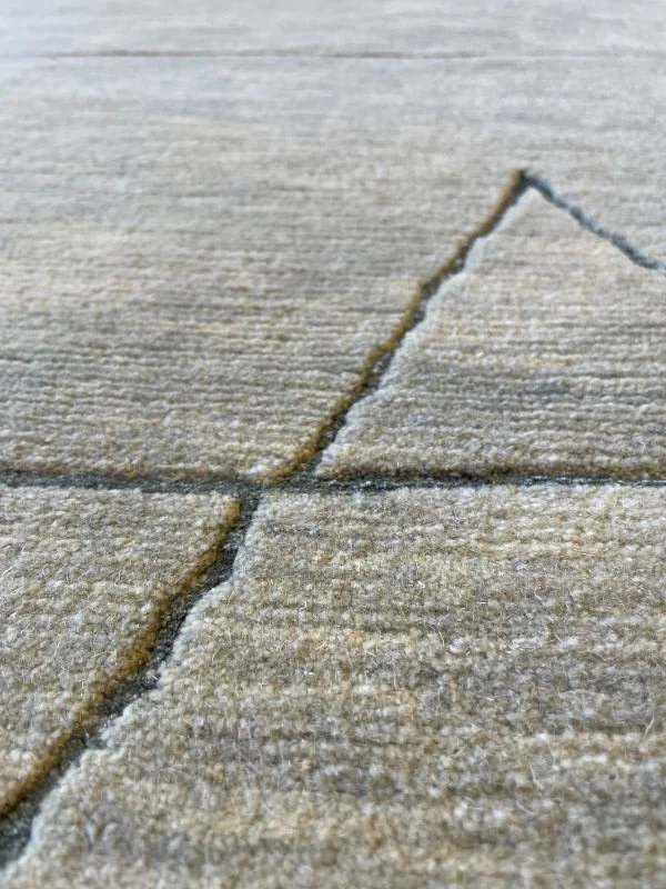 Close-up angled image of a sage rug with a geometric pattern