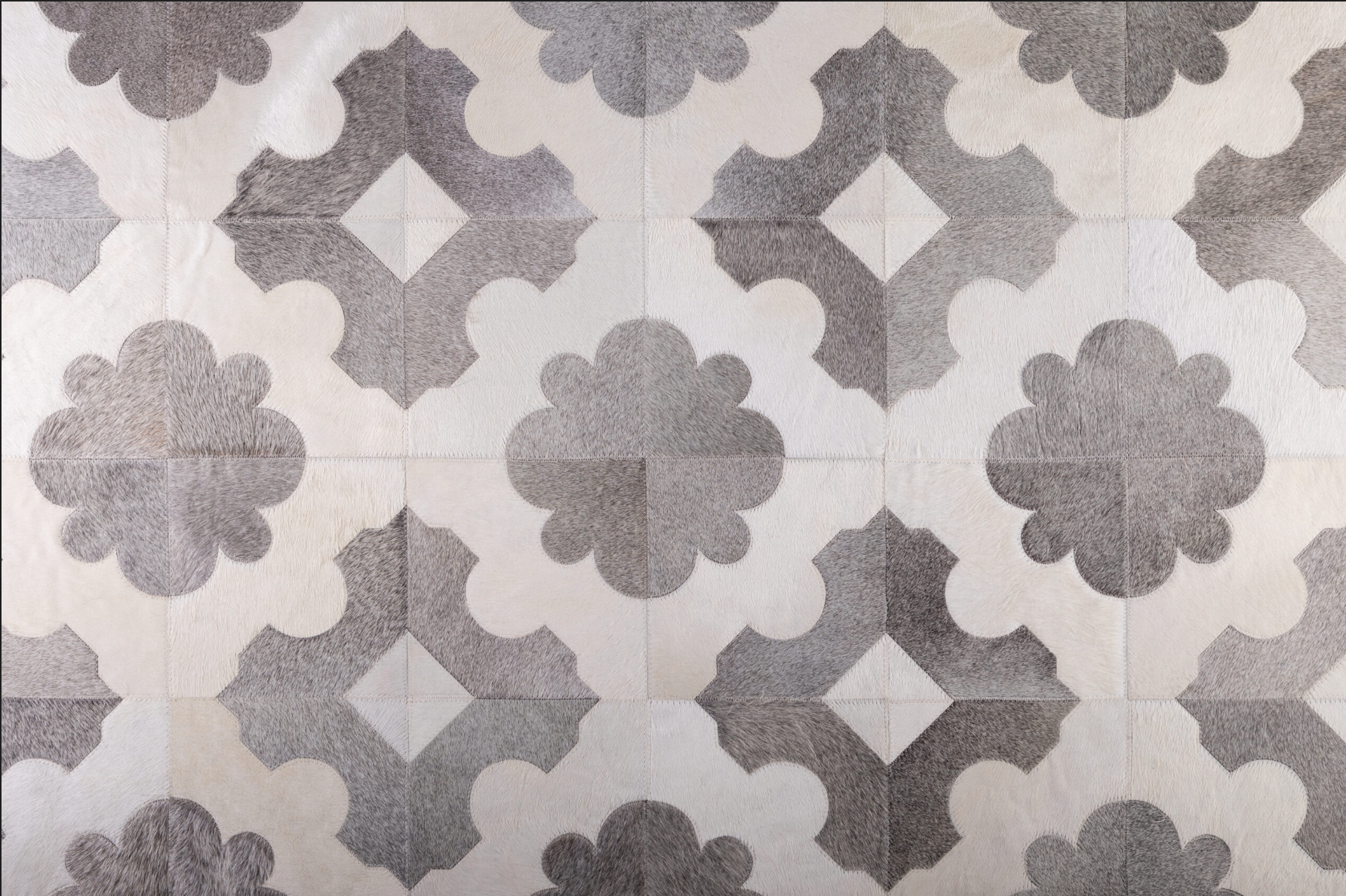 Patterned tile floor with black and white geometric and floral shapes.
