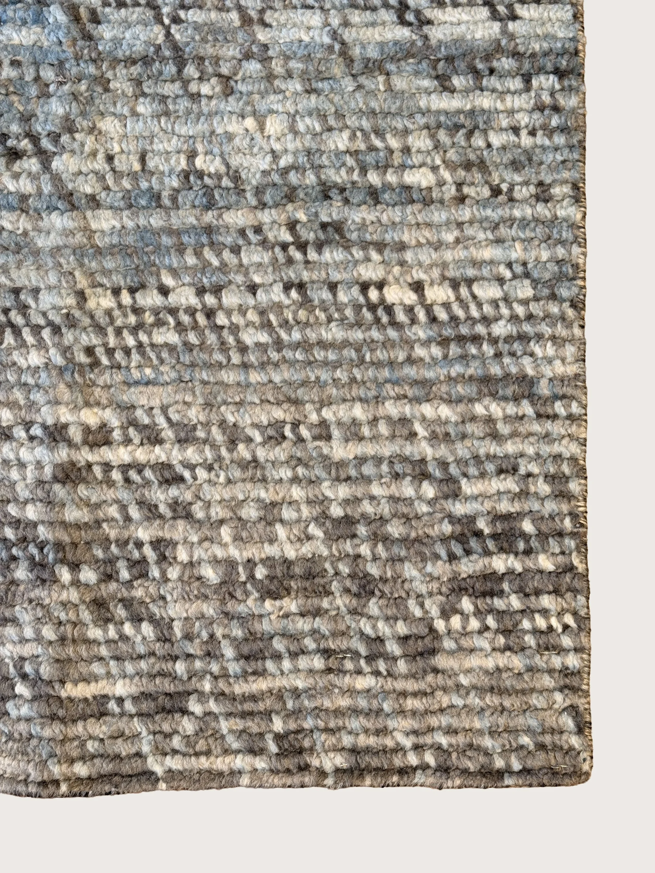 Close-up of a textured, patterned gray and beige area rug.