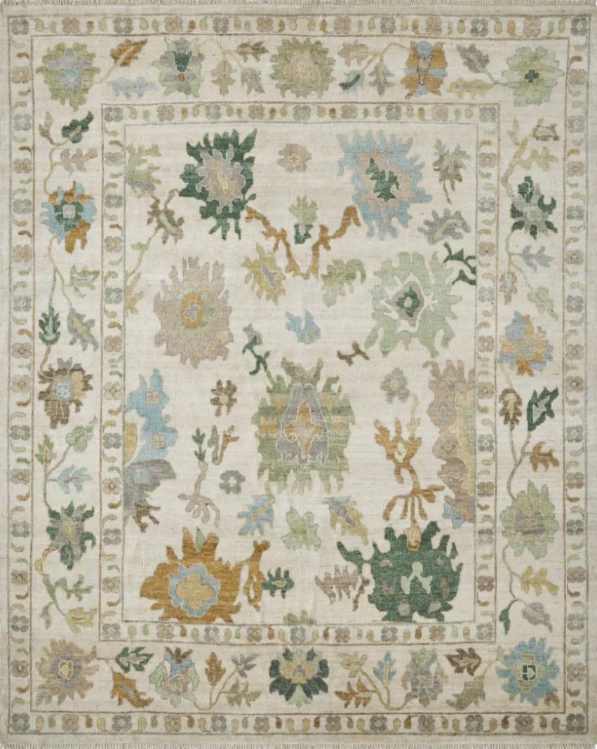 A traditional area rug with a floral pattern in shades of green, blue, beige, and gold, featuring a central medallion and a decorative border with various floral motifs.