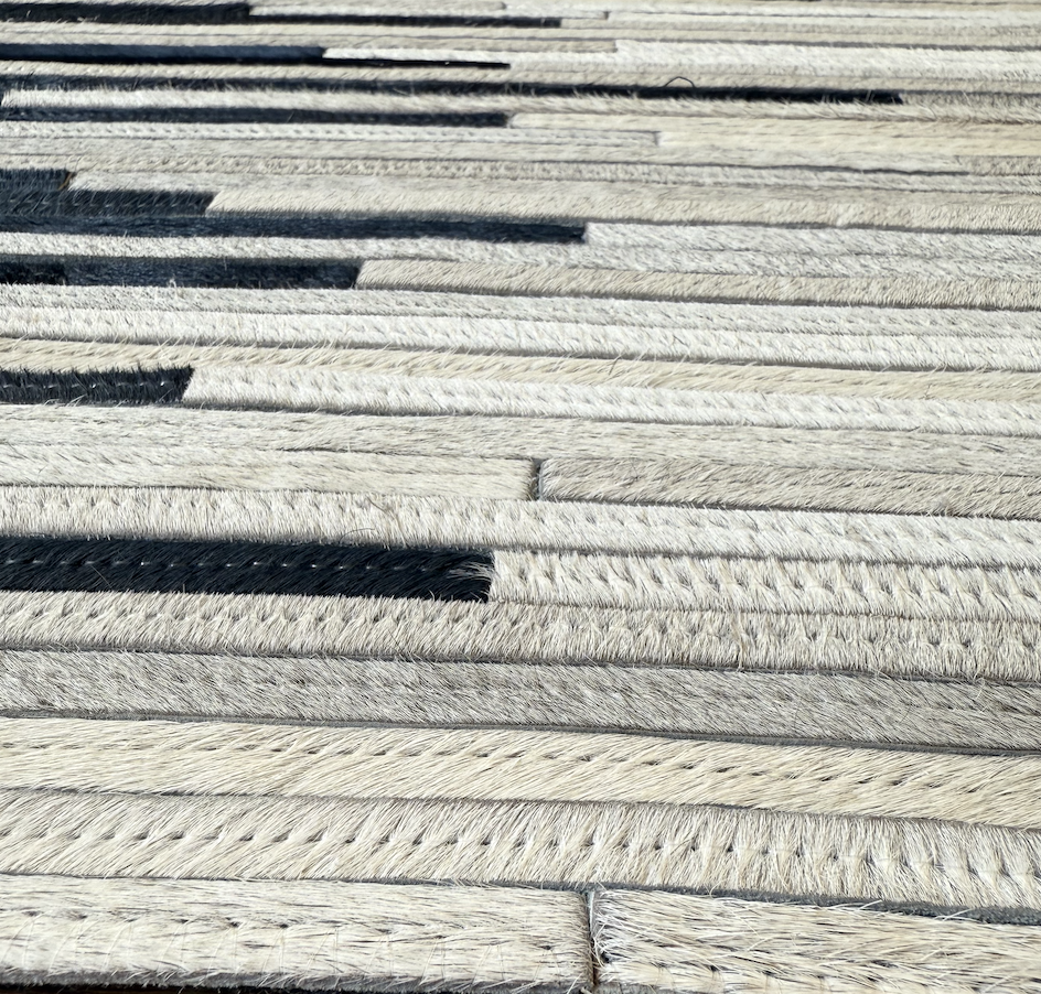 Close-up of multiple white and black ropes laid out parallel on a flat surface.