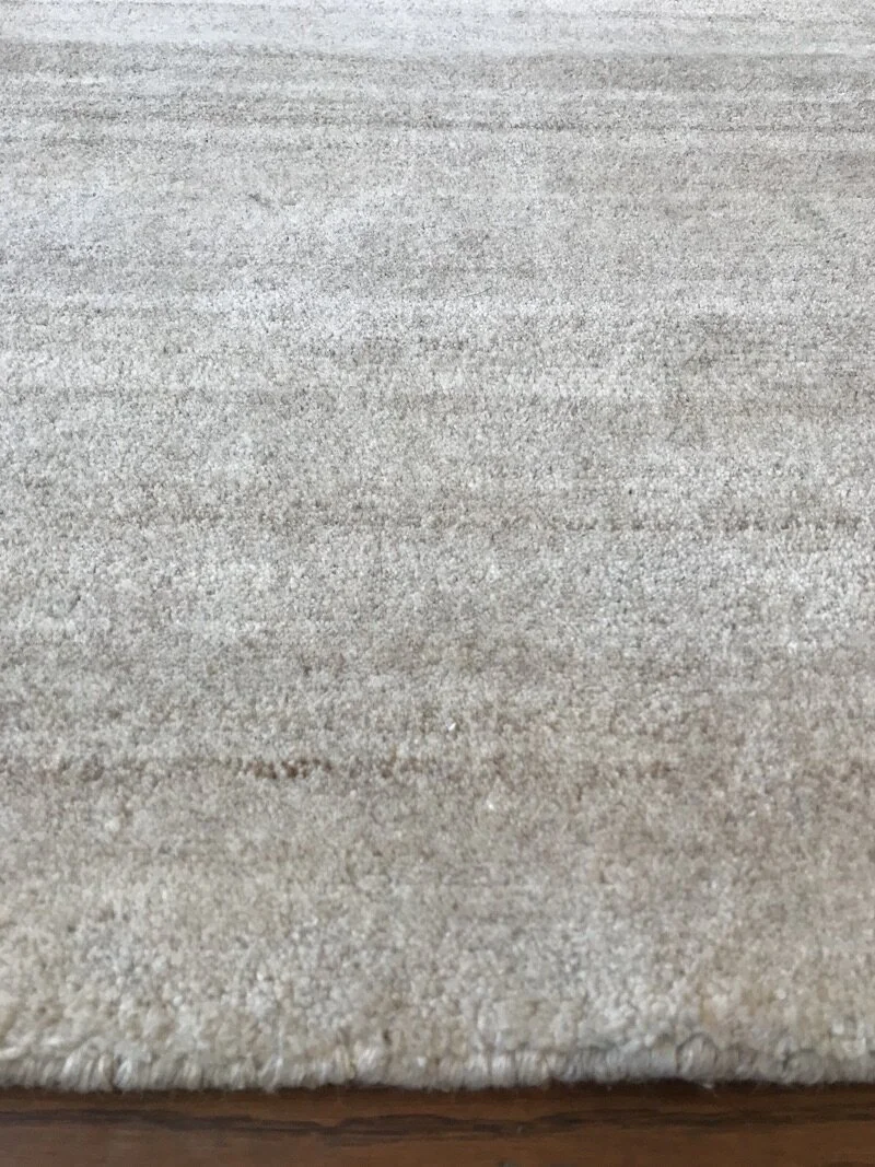 Close-up of a beige or light tan textured area, possibly a fabric or carpet surface.
