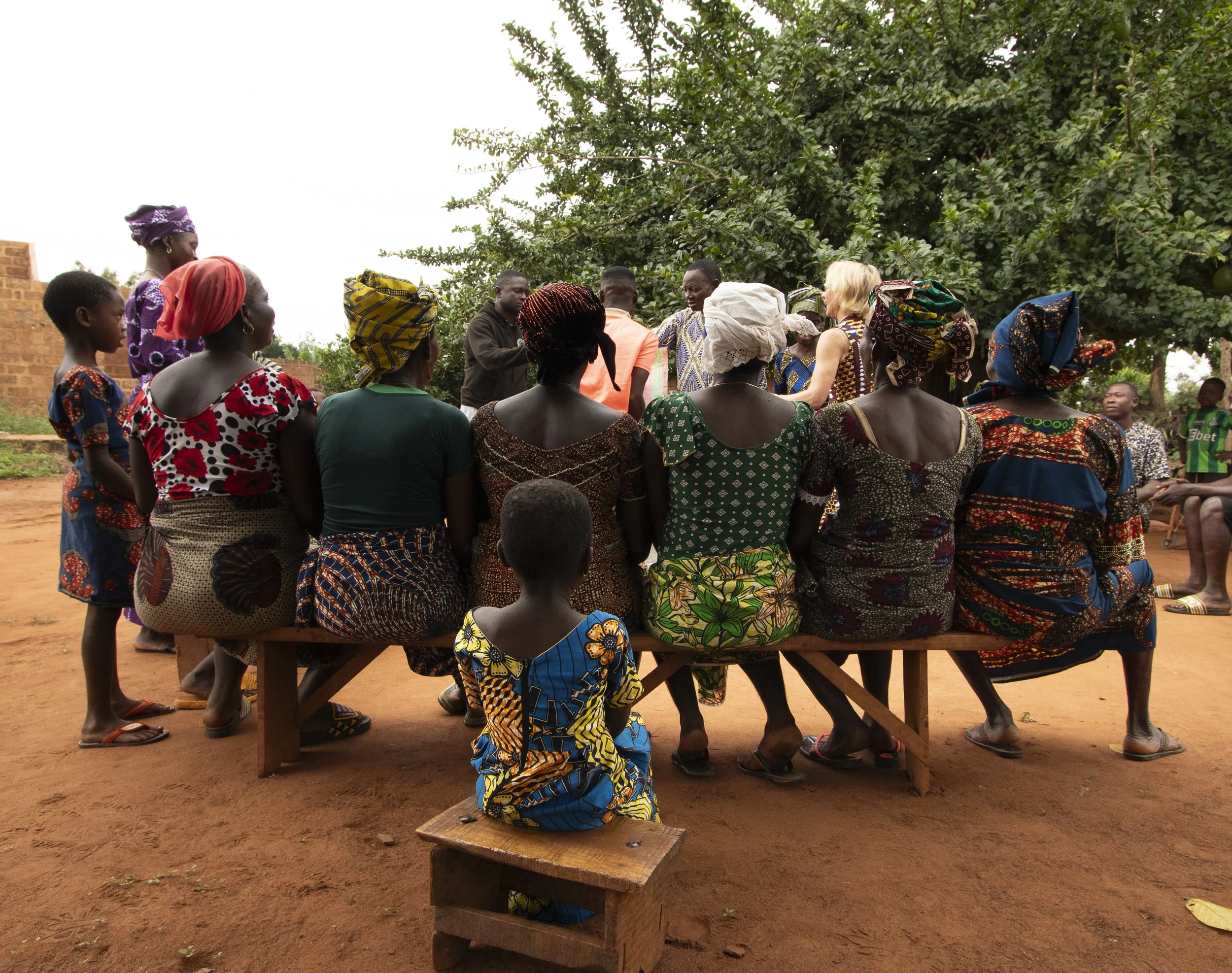 Young girl seated behind the adults listening into the meeting. August 2025.