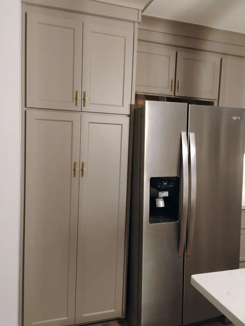 Kitchen with grey cabinets and a stainless steel side-by-side refrigerator.