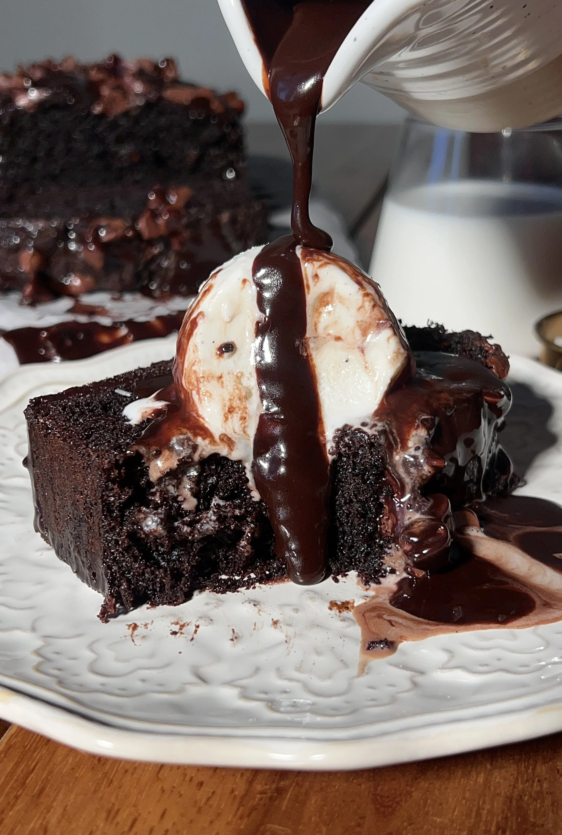 A warm and fudgy brown butter hot fudge brownie loaf with crisp edges, a gooey chocolate center, melty hot fudge sauce, vanilla ice cream, and flaky sea salt on top.