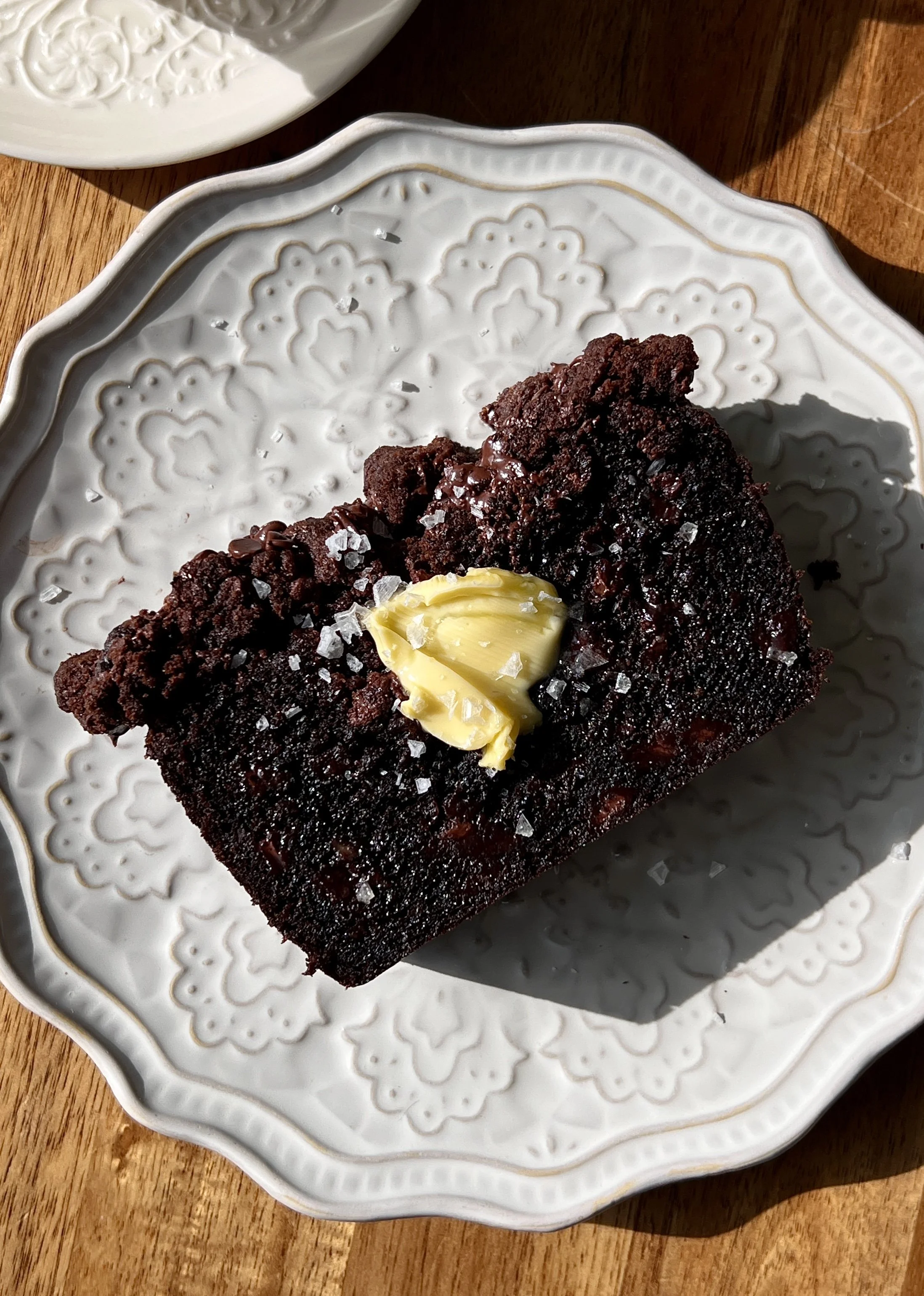 Close-up of a soft and fluffy double chocolate crumb banana bread with brown butter showing the rich chocolate crumb and melty chocolate chips throughout.