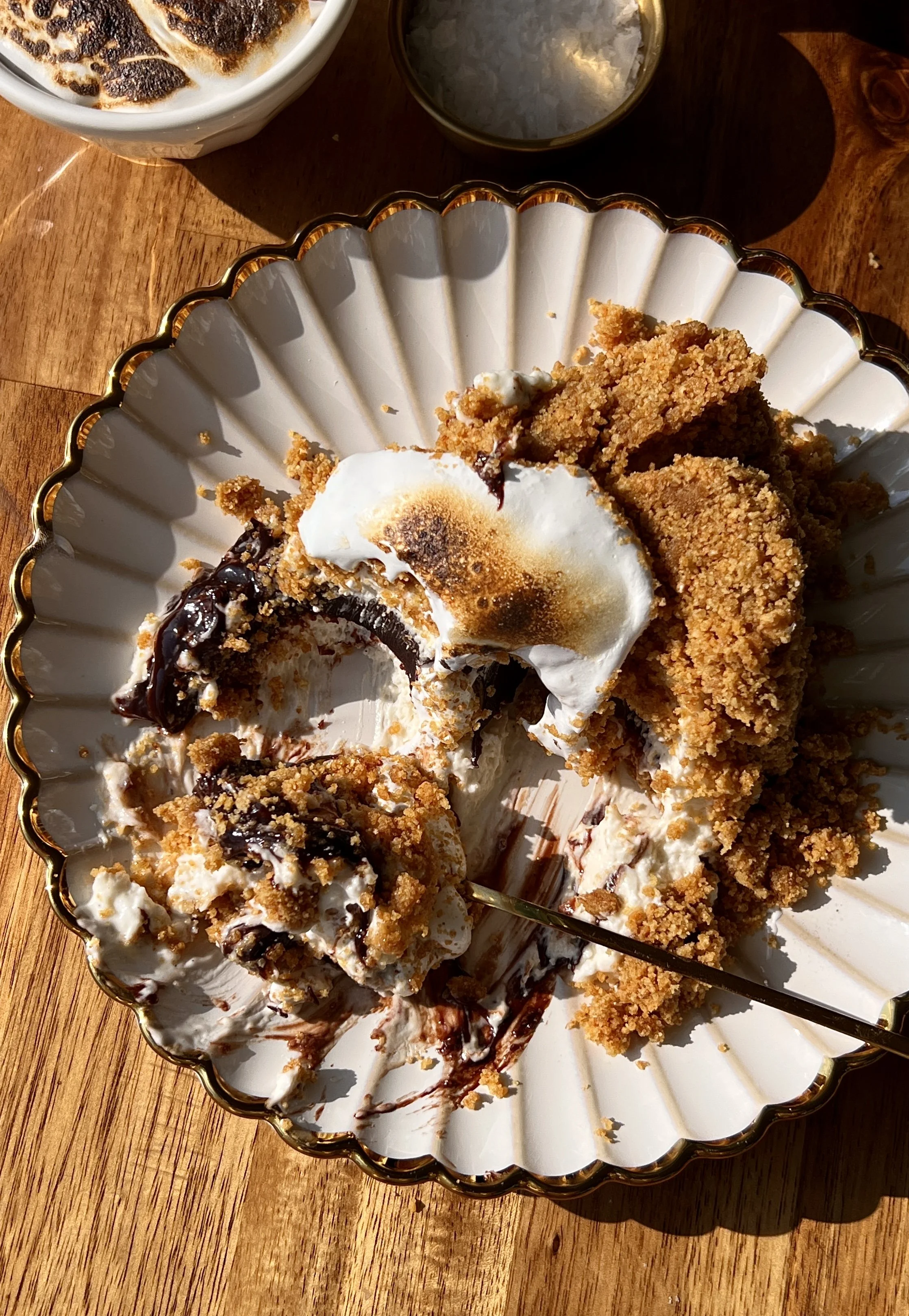 Upside down s'mores no-bake cheesecake with a perfectly crunchy graham cracker crust inverted to serve and finished with a dollop of toasted marshmallow fluff on top.
