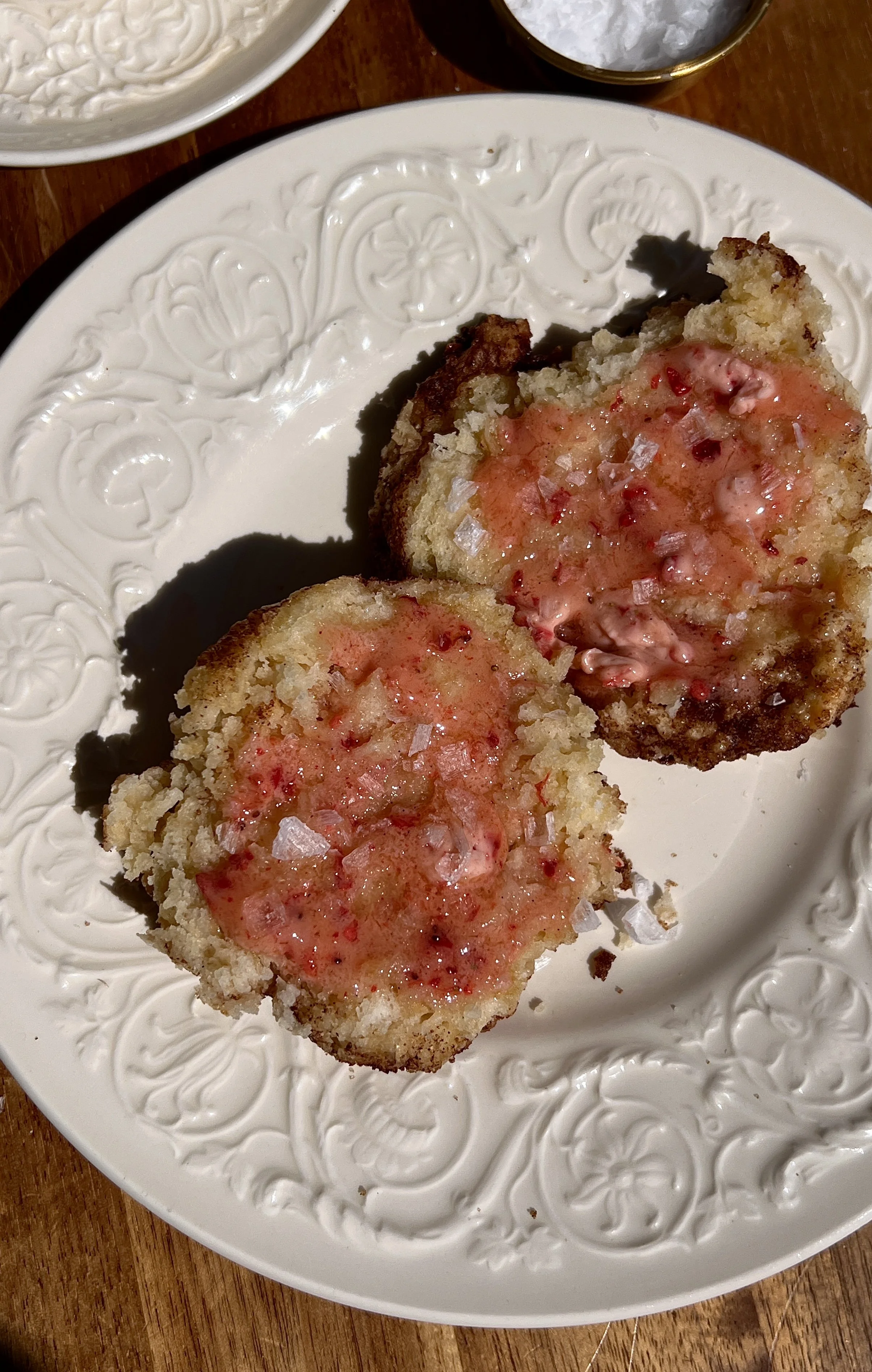Soft and fluffy cinnamon crunch sourdough cathead biscuits served warm with a generous spread of whipped strawberry honey butter, a sprinkle of flaky sea salt, and a hot cup of coffee.