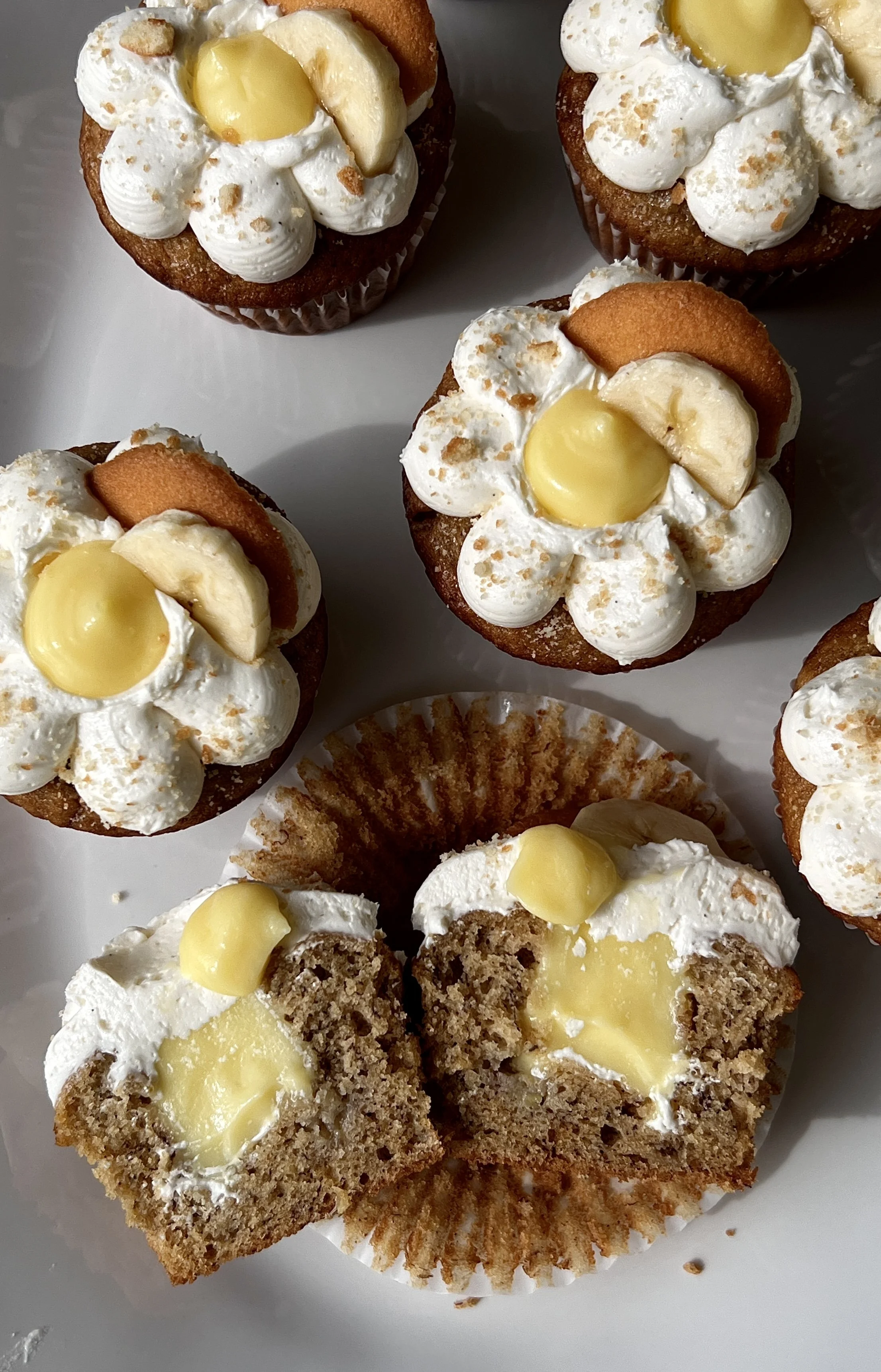 Close-up of a brown butter banana pudding cupcake filled with classic vanilla pudding and topped with light and fluffy whipped buttercream and crushed Nilla wafers.