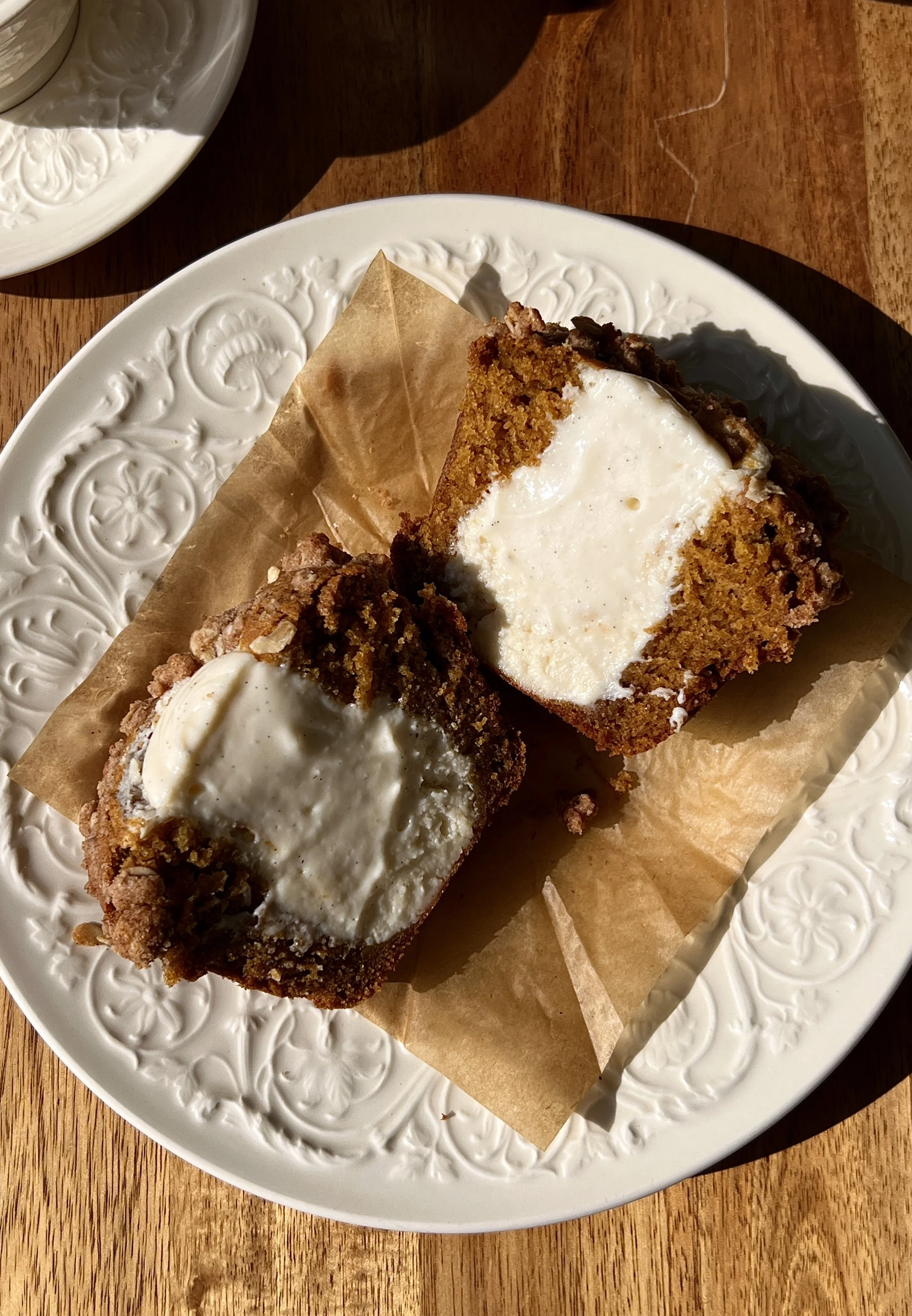 Soft and fluffy bakery-style pumpkin cream cheese muffins with brown butter packed with warm spiced pumpkin flavor and smooth tangy cream cheese filling finished with a buttery oat streusel served warm with a hot cup of coffee.