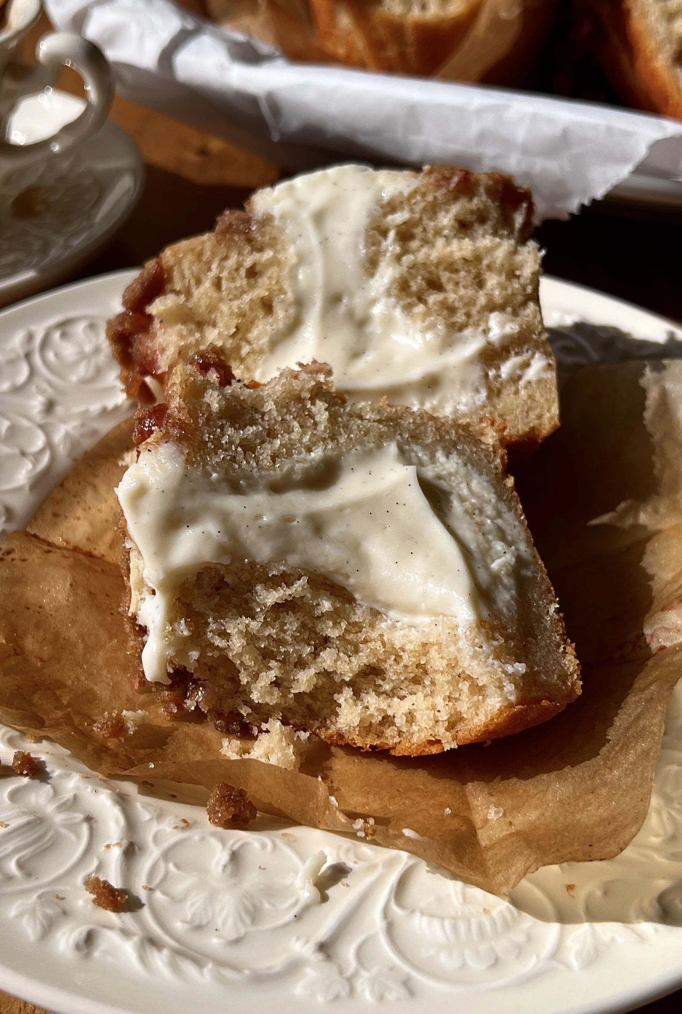 Bakery-style peach cobbler cream cheese muffin with a bite taken out showing the soft fluffy crumb, bright peach flavor, and rich tangy cream cheese center inside.