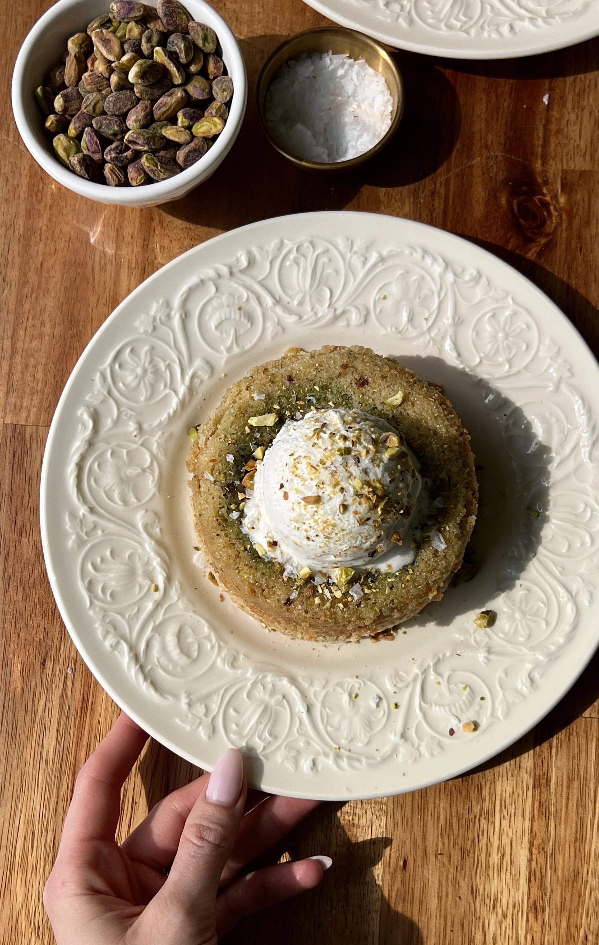 Warm and gooey pistachio cream lava cakes with a soft tender pistachio cake exterior served with a scoop of vanilla ice cream and a sprinkle of flaky sea salt.