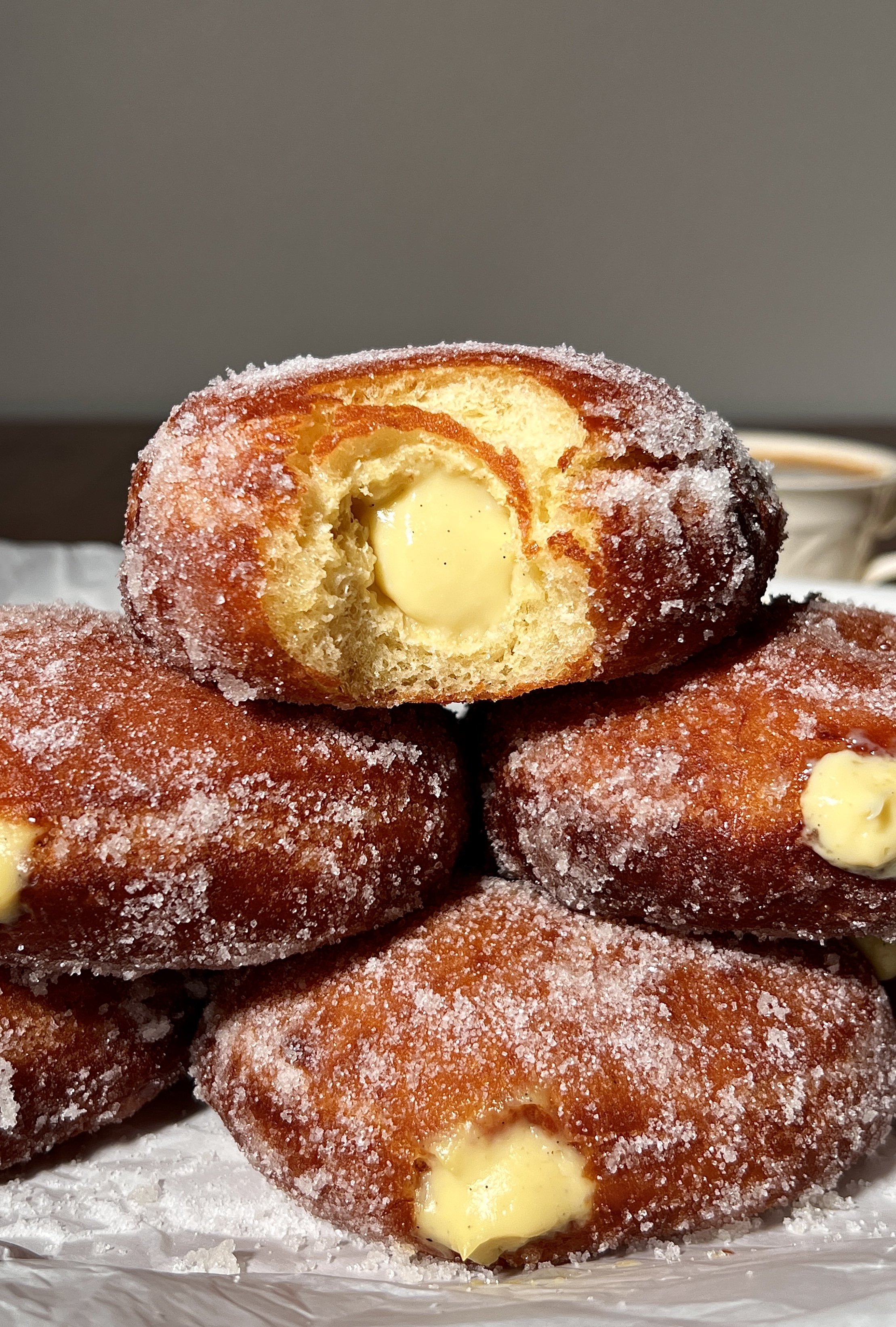 Close-up of vanilla bean coconut cream bomboloni showing the fluffy interior and rich coconut cream filling.