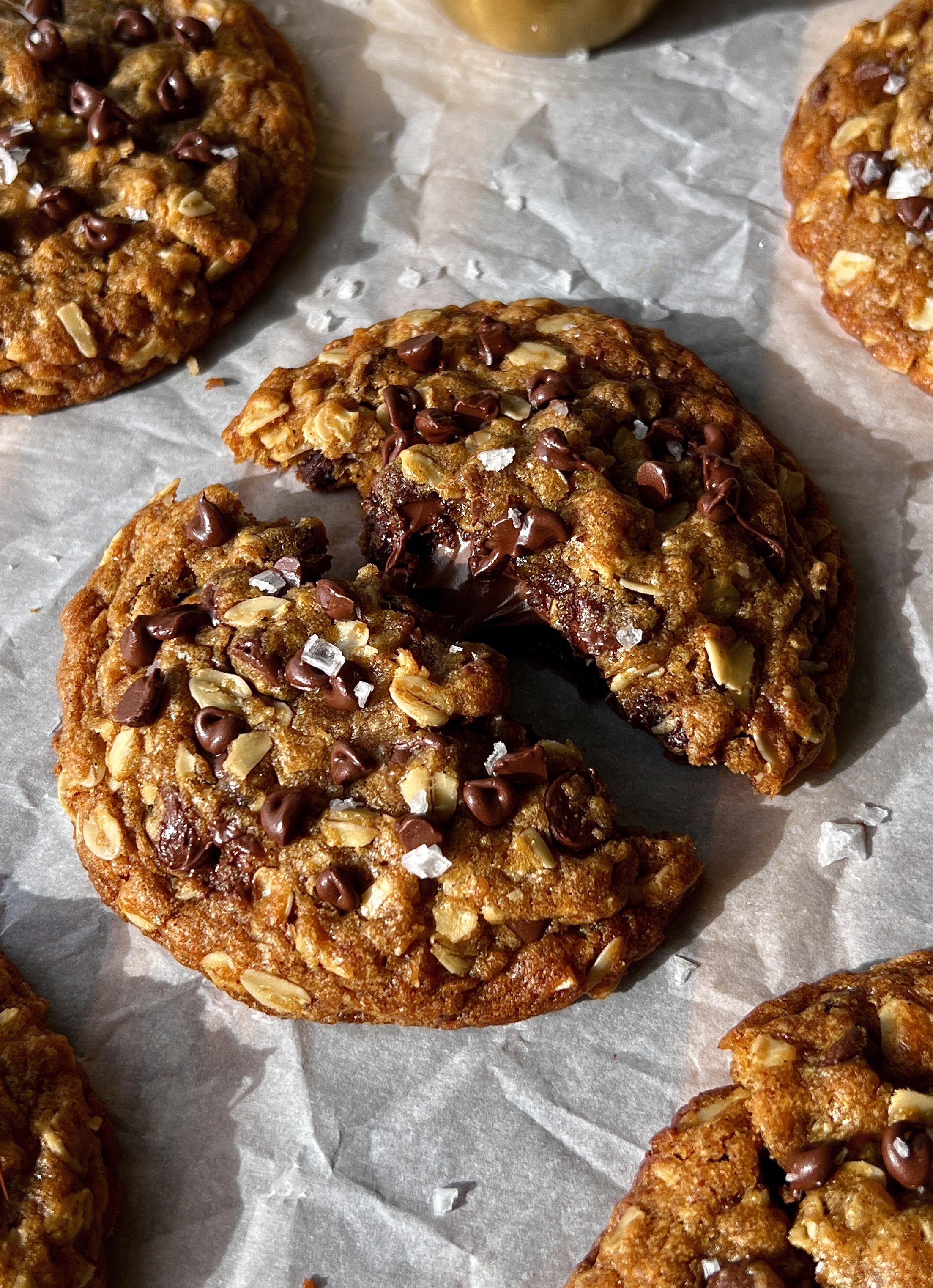 Nutella stuffed pumpkin oatmeal cookie with brown butter broken in half showing the gooey Nutella center melty chocolate chips and soft spiced pumpkin oatmeal cookie interior with perfectly crisp golden edges.